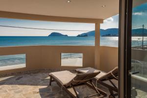 a balcony with chairs and a view of the ocean at Sea Shell Beach Suite in Laganas
