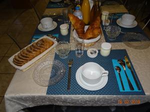 a table with a blue and white table set with pastries at La ferme aux chats in Formigny