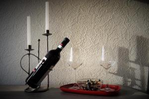 a bottle of wine on a table with two candles at BodenSEE Apartment "La Musica" in Meckenbeuren