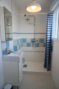 a bathroom with a sink and a tub and a shower at Le 27 - Cosy appartement centre-ville - WIFI in Royan
