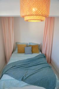 a bed with a blue comforter in a room at Le 27 - Cosy appartement centre-ville - WIFI in Royan