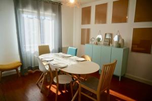 a dining room with a white table and chairs at Le 27 - Cosy appartement centre-ville - WIFI in Royan
