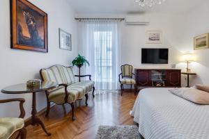 um quarto com uma cama, uma mesa e cadeiras em Central Palace Apartment em Zadar