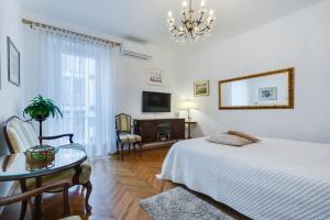 a bedroom with a bed and a table and a chandelier at Central Palace Apartment in Zadar