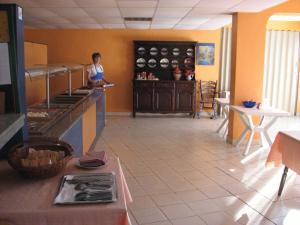 a man is standing in a kitchen with a counter at Hotel Horizont in Golden Sands