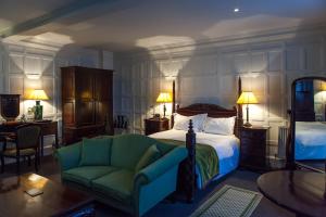a bedroom with a bed and a green couch at The Old Vine in Winchester