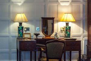 a desk with a mirror and two lamps on it at The Old Vine in Winchester