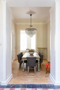 a dining room with a table and a chandelier at B&B Ar'Home in Kortrijk +31 photos
