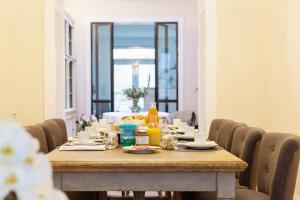 a wooden table with chairs around it with food on it at B&B Ar'Home in Kortrijk
