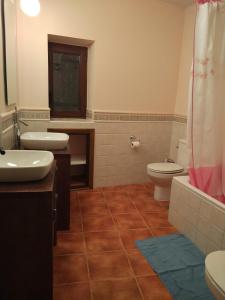 a bathroom with two sinks and a toilet and a shower at Casa Rural Vega del Tajuña in Armuña de Tajuña