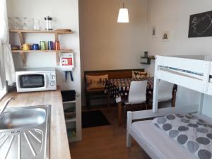 a kitchen and living room with a microwave at Fornhagi 2 in Akureyri