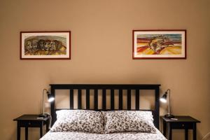 a bedroom with two pictures on the wall and a bed at Su Murdegu in Cagliari