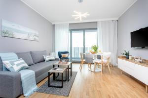 Sala de estar con sofá gris y mesa en Seaside Beach 150m do Plaży - Praia Apartments - Polsat Plus Arena, en Gdansk