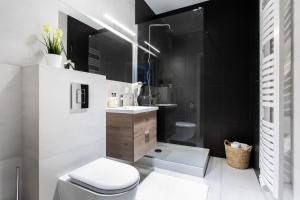 une salle de bain avec des toilettes blanches et un lavabo dans l'établissement Seaside Beach 150m do Plaży - Parking - Praia Apartments - Polsat Ergo Arena Plus, à Gdańsk