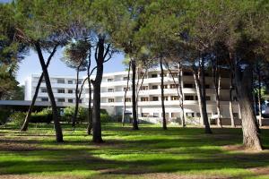 un edificio con muchos árboles delante de él en GH Campoverde Village, en San Cataldo