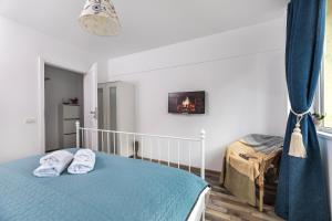 a bedroom with a bed with two towels on it at Ada Bucharest Apartment in Bucharest