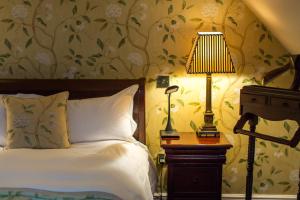 a bedroom with a bed and a table with a lamp at The Old Vine in Winchester