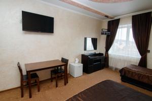 a hotel room with a desk and a television on the wall at Шахерезада in Vinnytsya