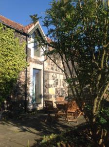 un patio con sillas y una mesa frente a una casa en Cutty Sark Cottage, en Kirkton of Largo