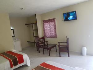 um quarto com duas camas e uma televisão na parede em HOTEL VILLA CALAKMUL em Xpujil