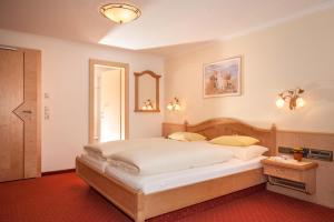 a bedroom with a large white bed in a room at Hotel Gletscherblick in Hippach