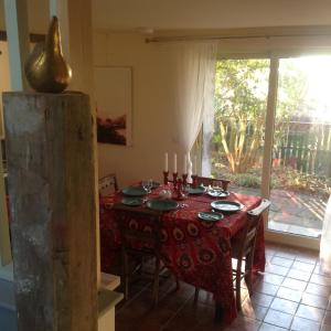 a dining room with a table with a red table cloth at Cutty Sark Cottage in Kirkton of Largo