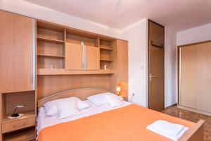 1 dormitorio con 1 cama grande con estanterías de madera en Apartment Kossi, en Split