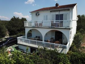 a white house with a balcony and a car at Apartment NECA in Lovište