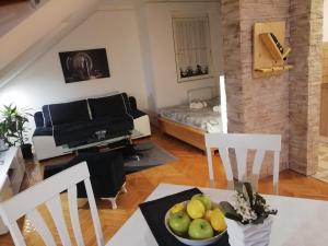 a living room with a couch and a table with a bowl of fruit at Two Kings apartment in Novi Sad