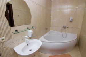 La salle de bains est pourvue de toilettes blanches et d'un lavabo. dans l'établissement Шахерезада, à Vinnytsia