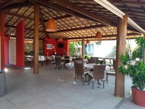 eine Terrasse mit Tischen und Stühlen in einem Restaurant in der Unterkunft Itacimirim - Quinta das Lagoas Residence in Itacimirim