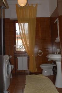 a bathroom with a toilet and a sink and a window at Casa Vacanza La Palma in Massa