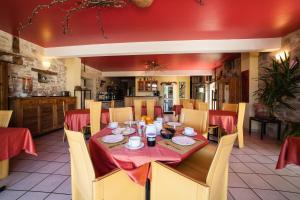 uma sala de jantar com uma mesa com toalha de mesa vermelha em Hôtel Restaurant Le Mûrier de Viels - Figeac Grand em Causse et Diege