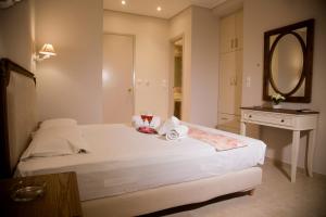 a bedroom with a large white bed and a mirror at Bellarias House in Nydri