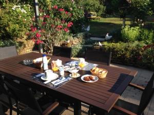 a wooden table with food on it in a garden at Le Chanois in Fontaine
