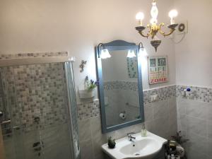 a bathroom with a sink and a shower and a mirror at New Maria's House Livorno. Il Cisternone in Livorno