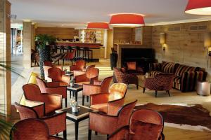 a lobby with chairs and a bar with a piano at MICHELS Wellness- & Wohlfühlhotel in Schalkenmehren