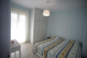 a bedroom with a bed and a desk and a window at Acharavi, villa next to the beach in Acharavi