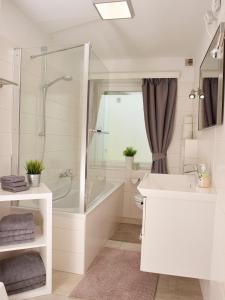 bagno con doccia, vasca e lavandino di Karwendel Apartments II a Scharnitz