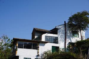 a white building with a tree on top of it at HOSPEDAJE BELLA VISTA MONGUI in Monguí