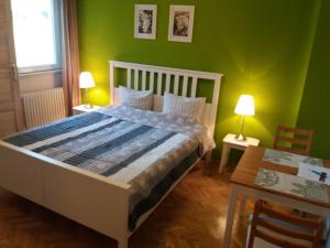a bedroom with a bed with green walls and a table at Budanest Apartments in Budapest