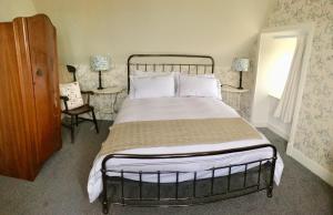 a bedroom with a large bed and a chair at Puffin Cottage in John O Groats