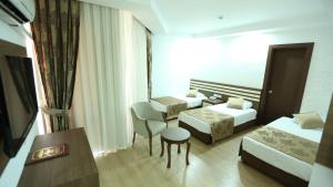 a hotel room with two beds and a table and a chair at Olbia Hotel in Antalya +35 photos