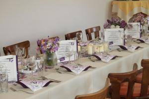 a long table with a white table cloth and flowers on it at Landhotel-Restaurant Willingshofer in Gasen