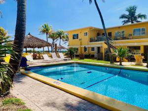 a swimming pool in front of a building at Ebb Tide Resort in Pompano Beach
