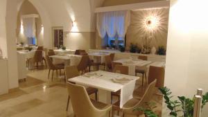 a dining room with white tables and chairs at MONUN Hotel&Spa in Grottaglie