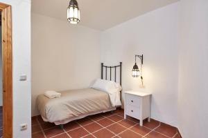 Habitación pequeña con cama y mesita de noche en La Almunia de la Alpujarra, en Yegen