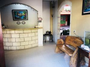 a living room with a bench and a brick wall at Hotel Marjenny in Copan Ruinas