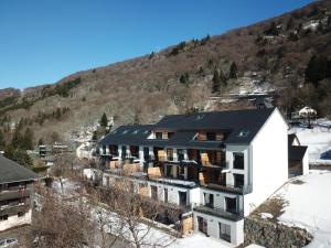 an aerial view of a building with a mountain in the background at Le B3 de Claire - Résidence La Montille in Le Mont-Dore