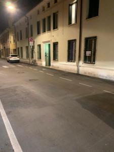 une rue vide avec une voiture garée devant un bâtiment dans l'établissement Dante Centro, à Ravenne